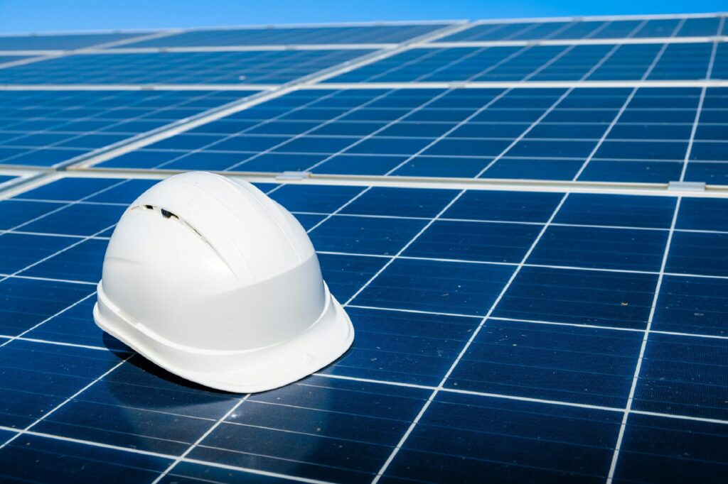 Rooftop solar panel installation equipment and safety helmet placed on solar panels, representing professional services by solar companies in Kerala for residential solar energy systems.