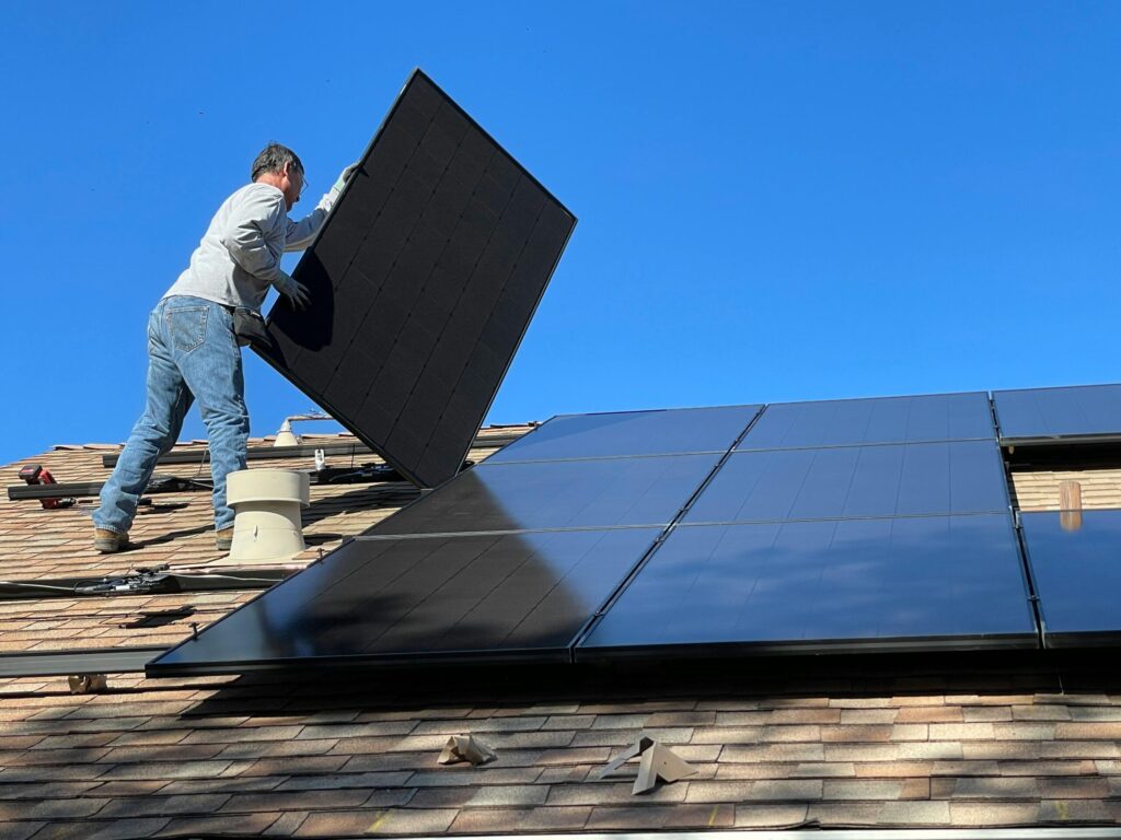 Technician installing rooftop solar panels on a residential home, highlighting the growing demand for reliable solar companies in Thrissur for rooftop solar system installations.